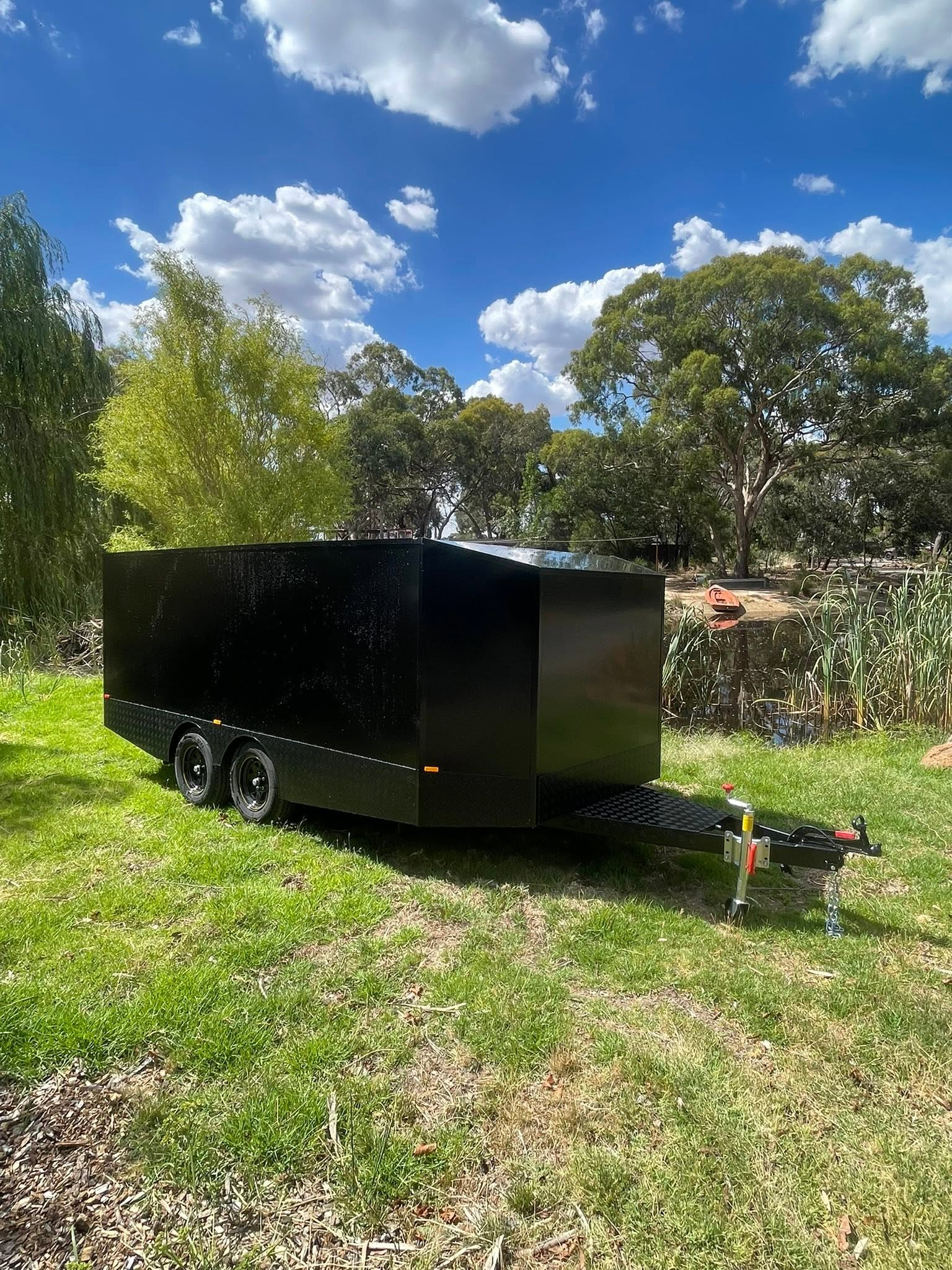 Black tandem custom toy hauler in a country setting