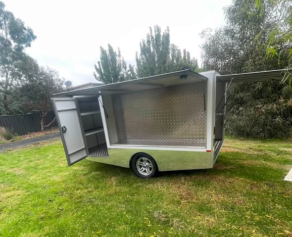 Grey custom trailer exterior with lift-up side access